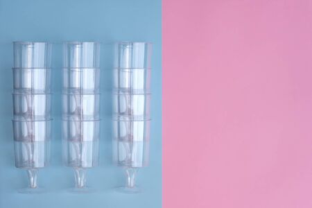 transparent plastic utensils for desserts in pastel pink and blue colors. Copy space, flat layの写真素材