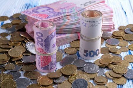 Bundles ukrainian banknotes value of 200 and 500 hryvnia UAH and pile of coins. Closeup viewの写真素材