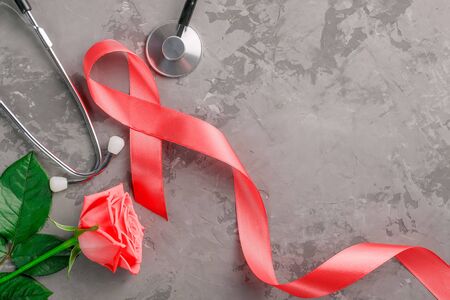 red ribbon, stethoscope and rose on a concrete background. 1 December World AIDS Day, HIV illness campaign. Copy space for textの写真素材