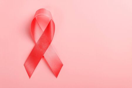 red ribbon on a pink background. 1 December World AIDS Day, HIV illness campaign. Copy space for textの写真素材