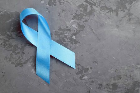 Blue ribbon on concrete surface, prostate cancer awareness concept. Copy space for textの写真素材