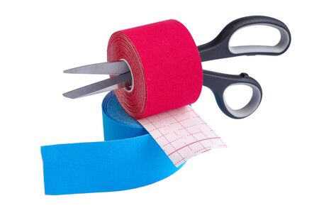 two rolls kinesiology tape for athletes and scissors isolated on white background. Kinesiology taping manipulate nerve receptors and reduces pain in muscles and speeds up the healing processの写真素材