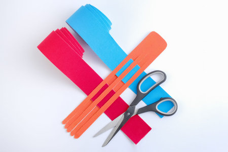 two rolls kinesiology tape for athletes and scissors on white background, top view. Kinesiology taping manipulate nerve receptors and reduces pain in muscles and speeds up the healing processの写真素材
