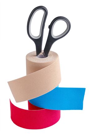 Stack ofthree rolls kinesiology tape for athletes and scissors isolated on white background. Kinesiology taping manipulate nerve receptors and reduces pain in muscles and speeds up the healing processの写真素材