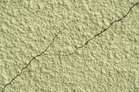 olive painted chipped plaster on the wall weathered with cracks and scratches.の写真素材