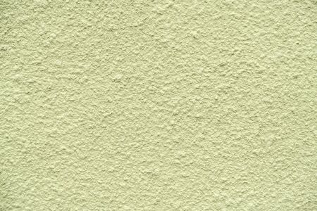 olive painted chipped plaster on the weathered wallの写真素材