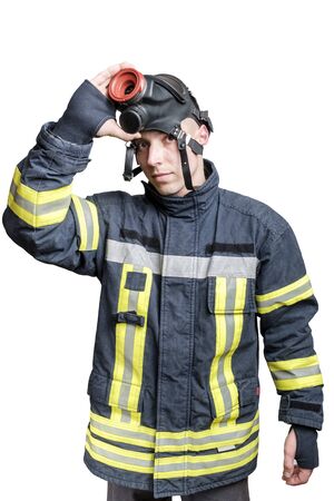young firefighter in uniform takes off protective breathing mask from his head. Isolated om white backgroundの写真素材