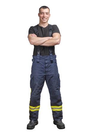 Young smiling firefighter with folded arms wearing black t-shirt and fireproof pants with suspenders. isolated on a white backgroundの写真素材