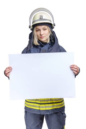 young beauty firefighter wearing uniform and helmet looking to the camera and holding empty paper sheet in hands. isolated on white backgroundの写真素材