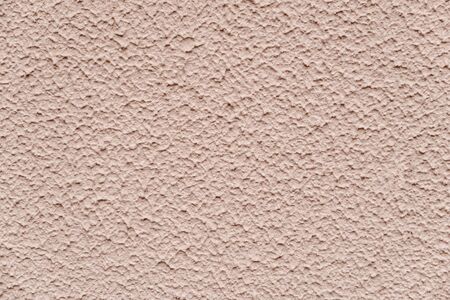 Beige chipped textured paint with sand on the wall. close up viewの写真素材