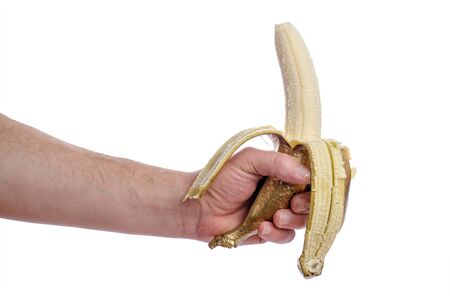 Human hand hold's peeled golden banana isolated on white background. Creative concept with painted fruits.の写真素材