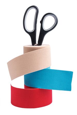 Stack of three rolls kinesiology tape for athletes and scissors isolated on white background. Kinesiology taping manipulate nerve receptors and reduces pain in muscles and speeds up healing processの写真素材