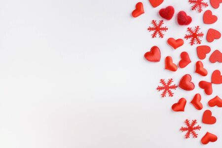 Festive composition from red hearts and snowflakes scattered on white background, valentines day concept, copy space for text, flatlayの写真素材