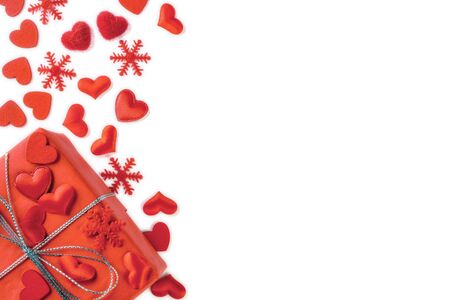 Festive composition from red gift box, snowflakes and hearts scattered and isolated on white background, valentines day concept, copy space for text, flatlayの写真素材