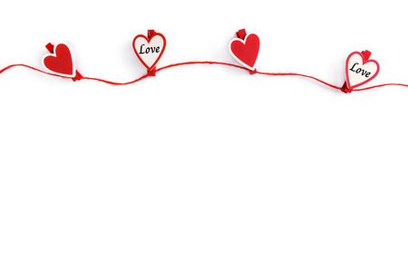 Red and white hearts hanging on rope isolated on white. Valentine's Day concept. Greeting card with copy space for your text or advertising on white backgroundの写真素材
