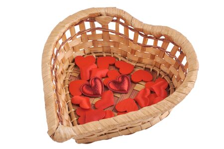 Small hearts in a wicker heart-shaped basket isolated on white. Close-up viewの写真素材