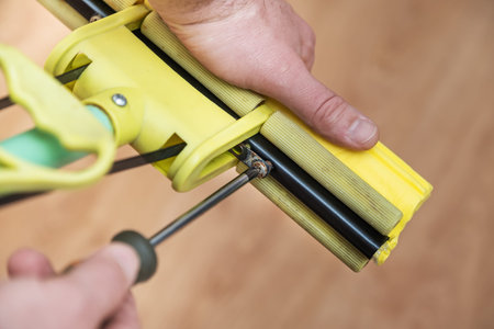 process of replacing a yellow sponge on a plastic mop with a self-tapping screw and a screwdriver