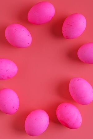 vertical frame of Easter Eggs On Pink Background, flat lay, top view, copy spaceの写真素材