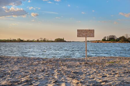 Signpost with copy space for text along the sand beach of the river. Contaminated water, quarantine, virus outbreak, access fee limitation concept.の写真素材