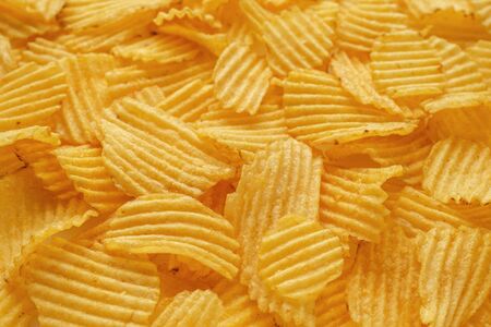 Golden potato chips background. Selective focus, copy space for textの写真素材