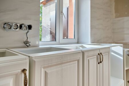 Light interior and installation process white kitchen furniture. Selective focusの写真素材