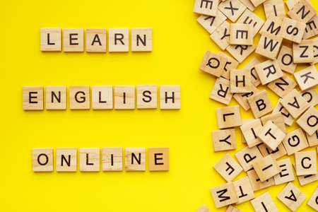 wooden letters with phrase learn english online on yellow background.の写真素材