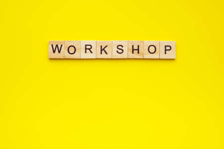 text workshop made with wooden letters on yellow background.の写真素材