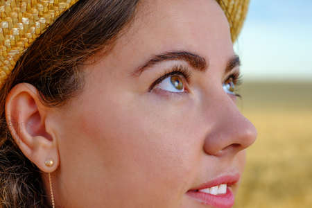 portrait of a smiling woman in straw hat in wheat field at sunrise.の写真素材