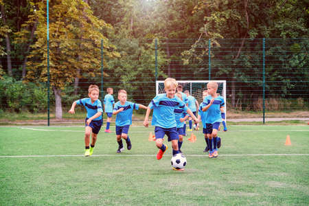 Kids running and kicking soccer balls on children football training sessionの写真素材