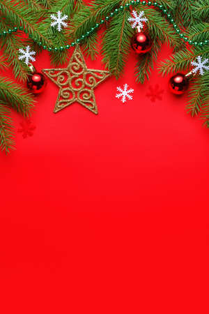 Top view Christmas composition with spruce branches and toys on red backgroundの写真素材