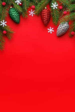 Top view Christmas composition with spruce branches and toys on red backgroundの写真素材