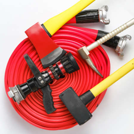 Large yellow sledgehammer, axe, hooligan pinch-bar and rolled fire hose from firemans toolbox on white background. Top view, flat layの写真素材