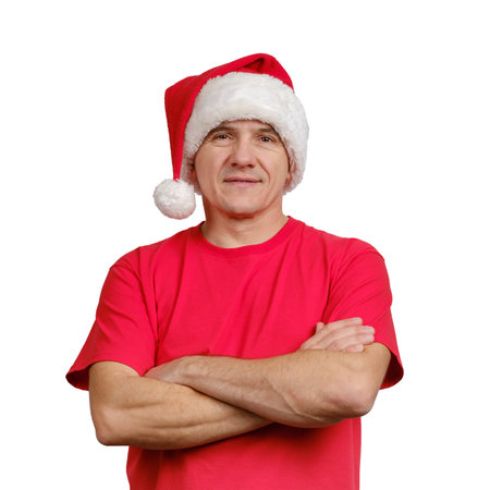 Portrait handsome man wearing Santa hat and red informal t-shirt with folded arms isolated on white backgroundの写真素材
