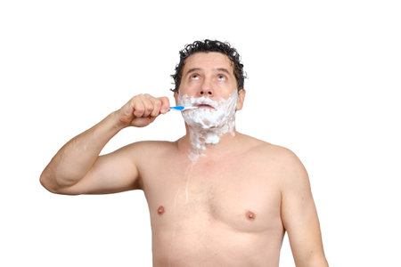 Sad middle-aged white man holds toothbrush in his mouth, brushing teeth, shaving, looks up and hurry, being late for work or meeting, overslept, isolated on white background.の写真素材