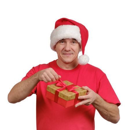 Portrait of a middle-aged smiling man in Santa hat opening gift box and looking at camera isolated on white backgroundの写真素材