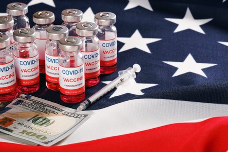American flag, coronavirus vaccine vials, syringe and money for purchase or trading vaccine concept.の写真素材