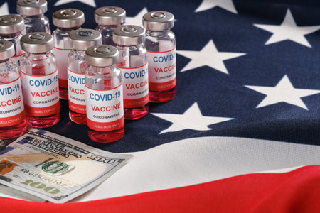 American flag, coronavirus vaccine vials and money for purchase or trading vaccine concept. Copy space for textの写真素材