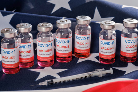 American flag, coronavirus vaccine vials and syringe. Vaccination against COVID-19 SARS-CoV-2 coronavirus pandemicの写真素材