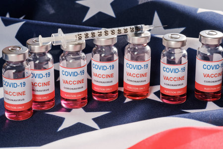 American flag, coronavirus vaccine vials and syringe. Vaccination against COVID-19 SARS-CoV-2 coronavirus pandemic conceptの写真素材