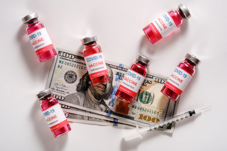 Top view of new infection vaccine with dollar bills on white backgroundの写真素材