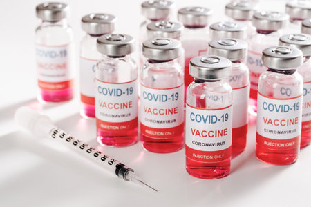glass vaccine vial and syringe for vaccination against pandemic on white backgroundの写真素材