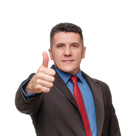 Portrait handsome man wearing suit and blue shirt showing thumb up isolated over white backgroundの写真素材