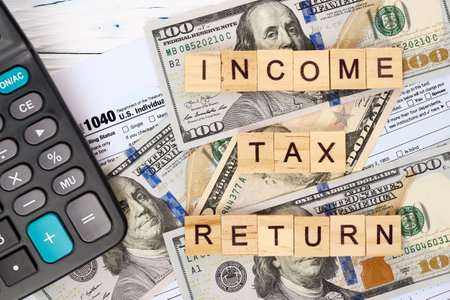 Personal income tax form 1040, dollar bills, calculator. Tax payment and filing concept.の写真素材