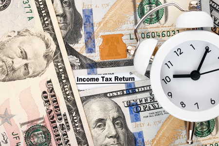 Personal income tax form 1040, dollar bills, alarm clock. Time to tax payment and filing concept.の写真素材