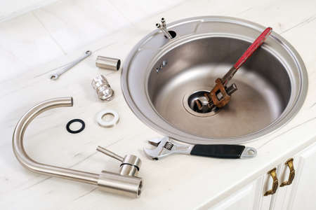 New faucet and tools for installing into the kitchen sink, plumbing work or renovation concept.の写真素材
