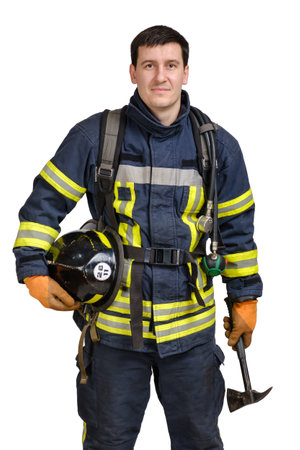 Young brave man in uniform of fireman holds axe and hardhat in his hands and looking at camera isolated on white backgroundの写真素材