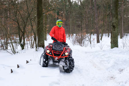 KYIV, UKRAINE - FEBRUARY 21, 2021: A man rides a quad bike in a snowy winter park. Seasonal leisure conceptのeditorial素材
