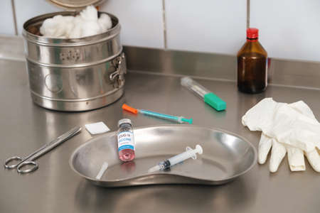 Used coronavirus vaccine vial in a steel medical tray, medical items. Immunization against Covid-19 conceptの写真素材