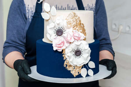 Unrecognized baker hands holding delicious festive cake closeupの写真素材