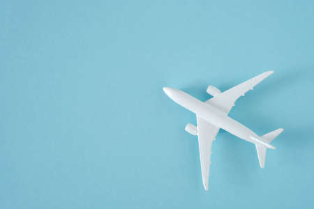 White airplane on blue background, top view, creative concept of air transportation, tourism, travel. Copy space for textの写真素材